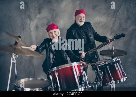 Photo de deux personnes retraité dame homme rock groupe populaire jouer concert instruments de tambour solo guitare night club porter un rocker tendance cuir tenue Banque D'Images