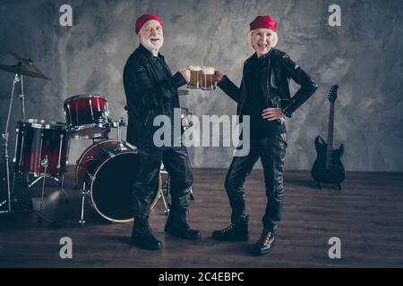 Photo pleine grandeur des retraités deux personnes amis dame homme groupe rock boire bière verre tambour instruments derrière porter élégant rocker cuir tenue Banque D'Images