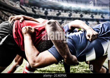 Image numérique composite de deux joueurs de rugby s'affrontant dans un stade sportif Banque D'Images