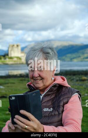 Lady prenant une photo au château d'Eilean Donan Loch Duich Highland Scotland Banque D'Images