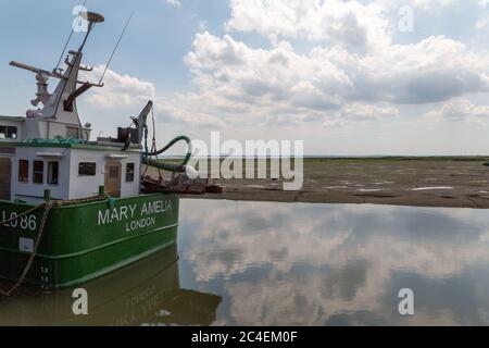 Leigh-on-Sea, Royaume-Uni. 26 juin 2020. Le navire MARY AMELIA, immatriculé à Londres, repose dans des eaux calmes à Leigh-on-Sea. La scène capture le cadre estuarien tranquille avec l'eau réfléchissante, le rivage boueux et la couverture nuageuse douce - contrastant l'industrie maritime avec la sérénité naturelle. Le bateau de pêche Mary Amelia à marée basse. Les gens à Old Leigh, Essex, apprécient le temps chaud et les plages moins fréquentées. Penelope Barritt/Alamy Live News Banque D'Images