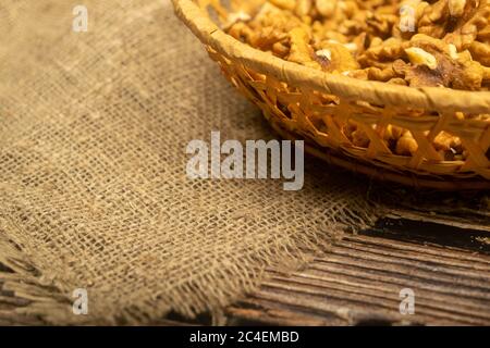 Noix pelées dans un panier en osier sur une table en bois recouverte de toile de jute à texture rugueuse. Une alimentation saine. Régime de remise en forme. Gros plan Banque D'Images