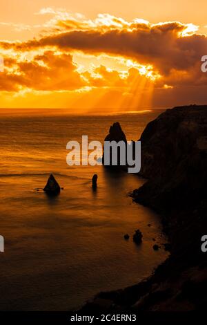 Un coucher de soleil rouge avec la silhouette d'une falaise au-dessus de la mer sur Fiolent Banque D'Images