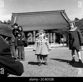 Enfant japonais posant pour le photographe de scène de rue des années 1950, Japon Banque D'Images