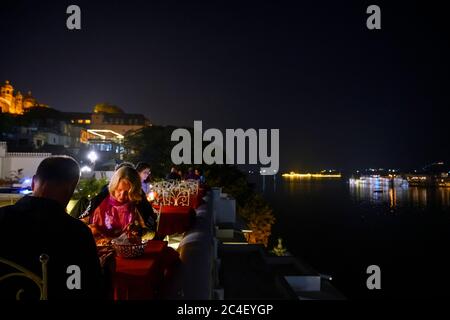 Terrasse de restaurant la nuit dans l'hôtel Jagat Niwas Palace avec une vue sur le lac Pichola, la vieille ville, Udaipur, Rajasthan, Inde Banque D'Images