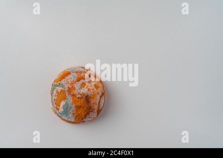 Le vieux citron moddy laid et non comestible isolé sur un fond de papier blanc texturé. Gros plan. Copier l'espace. Gestion des aliments, sur-approvisionnement, déchets, recyclage Banque D'Images