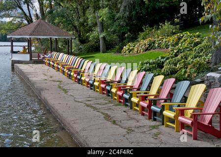 Vue panoramique sur les chaises de Muskoka multicolores du complexe touristique avec pavillon de jardin. Banque D'Images