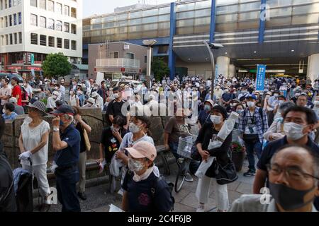 Tokyo, Japon. 26 juin 2020. Les personnes portant un masque de visage écoutent le discours du candidat du poste de gouverneur de Tokyo Kenji Utsunomiya lors d'un événement de campagne en dehors de la gare d'Akabane. Utsunomiya ancien président de la Fédération japonaise de l'Association du barreau et se présente pour devenir le prochain gouverneur de Tokyo. Les politiciens japonais Akira Koike et Renho sont venus soutenir la campagne d'Utsunomiya. L'élection du gouverneur aura lieu le 5 juillet. Credit: Rodrigo Reyes Marin/ZUMA Wire/Alay Live News Banque D'Images