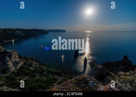 Nuit étoilée avec pleine lune sur mer, yachts et rochers en face. Le cap Fiolent, l'Orest et le Pilad se rochers sur le fond de la lune. Copier l'espace. Le Banque D'Images