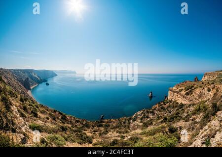 Vue panoramique sur la plage au coucher du soleil, avec une falaise rocheuse éclairée par le coucher du soleil. Exposition longue. Copier l'espace. Le concept de calme Banque D'Images