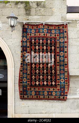 Tapis nationaux avec des motifs caucasiens sont à vendre dans la vieille ville sur des vieilles pierres Banque D'Images