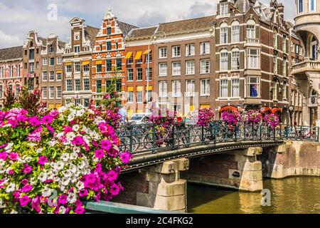 Amsterdam, pays-Bas - 18 juillet 2018 : pont sur un canal avec de nombreuses motos et fleurs à Amsterdam, Hollande. Photo de haute qualité Banque D'Images