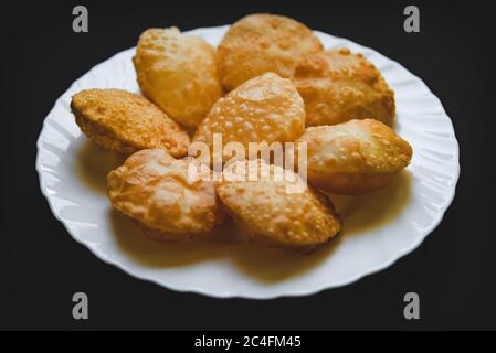 Poori traditionnel sud-indien avec fond noir sur une plaque blanche. Banque D'Images