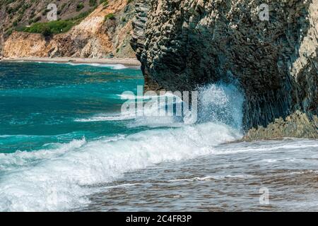 La vague océanique s'écrasant dans les roches de basalte columnaires côtières, comme en Islande. Pulvérisation marine. Eau azur Banque D'Images