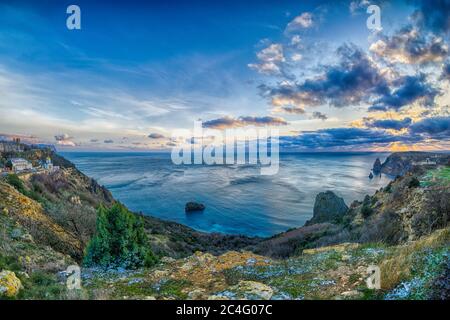 Vue panoramique sur la plage au coucher du soleil, avec une falaise rocheuse éclairée par le coucher du soleil. Exposition longue. Copier l'espace. Le concept de calme Banque D'Images