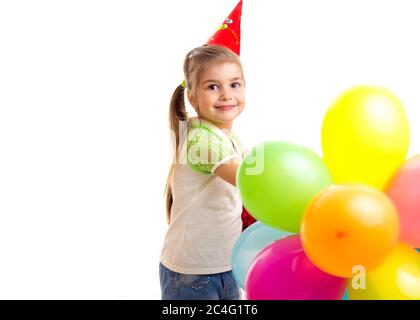 Petite fille souriante célébrant son anniversaire avec des ballons multicolores Banque D'Images