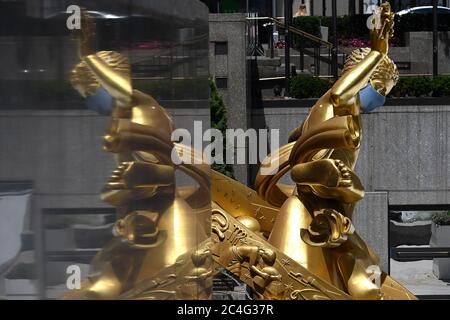 New York, États-Unis. 26 juin 2020. Prométhée, une sculpture en bronze doré de Paul Manship de 1934 située sur Rockefeller Plaza, est ornée d'un masque bleu pour promouvoir la deuxième phase de la réouverture de New York City et encourager la distanciation sociale pour arrêter la propagation de COVID-19, New York, NY, le 26 juin 2020. (Anthony Behar/Sipa USA) crédit: SIPA USA/Alay Live News Banque D'Images