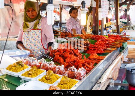 Phuket, Thaïlande - 4 avril 2010 : les femmes servent du poulet rôti sur le marché. C'est un favori thaïlandais. Banque D'Images