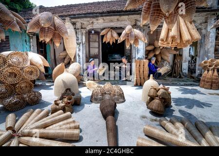Hung Yen province, Vietnam - 27 mai 2020: Des femmes non identifiées qui vivent dans un village traditionnel sont à tisser des bâtons de bambou pour fabriquer des produits de bambou. Ceux-ci Banque D'Images