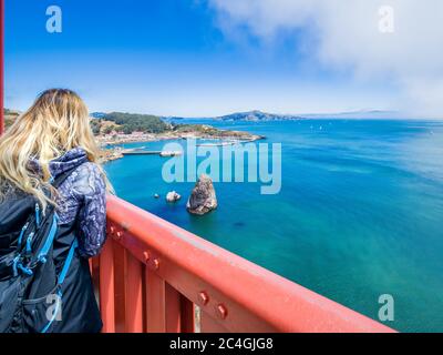 Une fille blonde s'admire du Golden Gate Bridge de San Francisco en Californie Banque D'Images