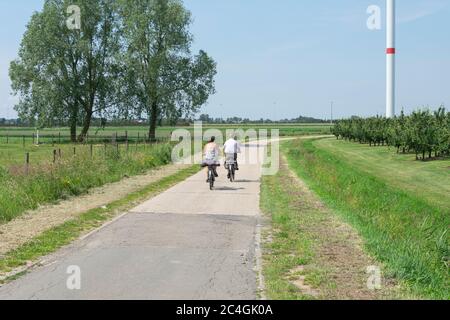 Sint Gillis Waas, Belgique, 18 juin 2019, couple plus âgé qui fait ses vélos sur une route déserte Banque D'Images