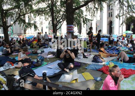 25 juin 2020, New York, New York, États-Unis : après des semaines de manifestations contre la brutalité policière et l'injustice raciale, les manifestants de la ville de New York campent devant l'hôtel de ville pour exiger des réductions de 1 milliard de dollars sur le financement du NYPD avant la date limite du budget du 1er juillet. Ces gens s'installèrent nuit et jour avec leur tente, leurs tapis et leurs sacs de couchage dans l'espace public qu'ils appellent « l'hôtel de ville d'Occupy ». Les défenseurs de la réforme de la police affirment que le budget de la police de la ville, qui représente près de 6 milliards de dollars, doit être considérablement réduit et réinvesti dans le logement, les soins de santé et d'autres services sociaux. (Image crédit : © Marie le BLE/ZUMA Banque D'Images