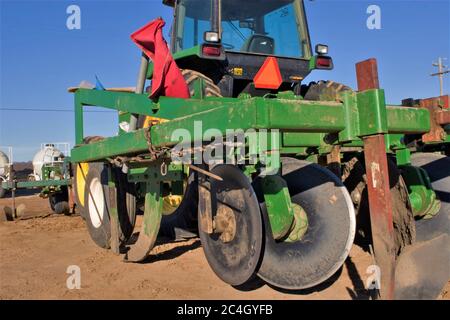 Disque agricole peint John Deere vert garé dans la cour d'équipement dans la cour des agriculteurs dans une ferme de fruits et légumes Santa Maria California avec du crochet rouge qui y est accroché Banque D'Images