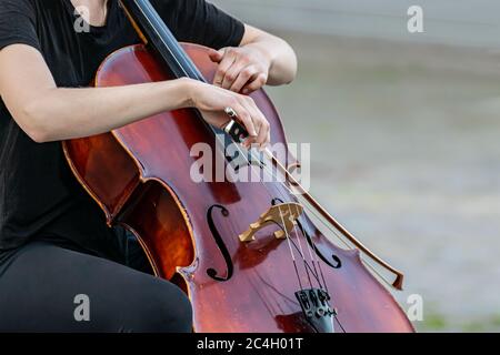 Femme jouant une double basse pendant un spectacle ou un récital de musique. gros plan mains, l'instrument et l'arc. Banque D'Images