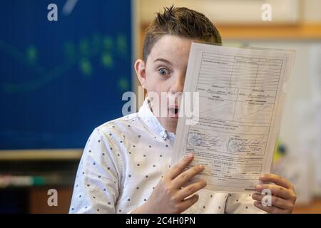 Liberec, République tchèque. 26 juin 2020. Un écolier reçoit un rapport à la fin de l'année scolaire, le 26 juin 2020, à Liberec, en République tchèque. Les élèves y ont des notes pour le deuxième semestre couvertes par des conseils spéciaux cette année, de sorte qu'elles sont illisibles à première vue. L'école proteste donc contre la façon dont les élèves sont évalués pendant la période touchée par la pandémie du coronavirus. Crédit: Radek Petrasek/CTK photo/Alay Live News Banque D'Images