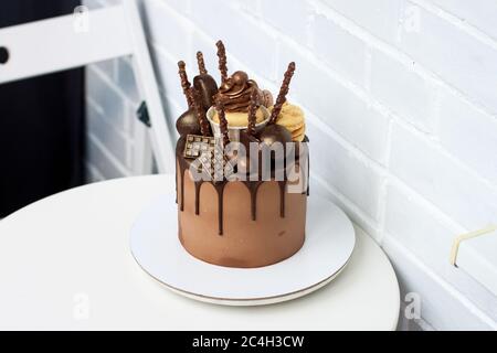 Gâteau d'anniversaire au chocolat élégant avec chocolat noir fondu, gâteau, gâteau, biscuits et bonbons sur fond blanc. Banque D'Images