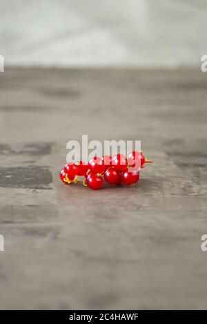 Les raisins de Corinthe rouges sont éparpillés sur un fond de texture grise. Photo de haute qualité Banque D'Images