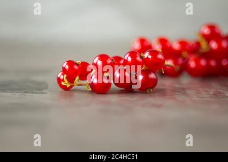 Les raisins de Corinthe rouges sont éparpillés sur un fond de texture grise. Photo de haute qualité Banque D'Images