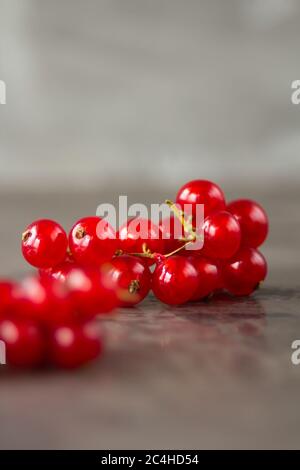 Les raisins de Corinthe rouges sont éparpillés sur un fond de texture grise. Photo de haute qualité Banque D'Images