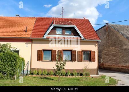 Petite maison familiale de banlieue entièrement rénovée avec de nouvelles fenêtres à cadre en bois et des stores ouverts entourés de maisons anciennes Banque D'Images