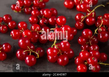 Les raisins de Corinthe rouges sont éparpillés sur un fond de texture grise. Photo de haute qualité Banque D'Images