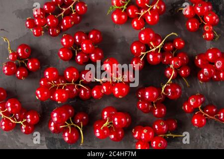 Les raisins de Corinthe rouges sont éparpillés sur un fond de texture grise. Photo de haute qualité Banque D'Images
