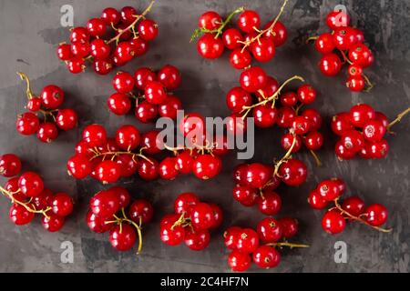 Les raisins de Corinthe rouges sont éparpillés sur un fond de texture grise. Photo de haute qualité Banque D'Images