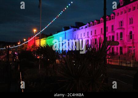 Llandudno , pays de Galles 26 juin 2020. La promenade de Llandudno a été illuminée dans les couleurs de l'arc-en-ciel jeudi soir pour soutenir les travailleurs de soins pendant la pandémie du coronavirus. Le bâtiment le long de la promenade a été illuminé pour montrer l'appréciation au personnel du NHS, aux travailleurs de soins et aux autres travailleurs clés crédit : Mike Clarke Alay Live News Banque D'Images