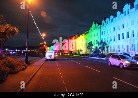 Llandudno , pays de Galles 26 juin 2020. La promenade de Llandudno a été illuminée dans les couleurs de l'arc-en-ciel jeudi soir pour soutenir les travailleurs de soins pendant la pandémie du coronavirus. Le bâtiment le long de la promenade a été illuminé pour montrer l'appréciation au personnel du NHS, aux travailleurs de soins et aux autres travailleurs clés crédit : Mike Clarke Alay Live News Banque D'Images