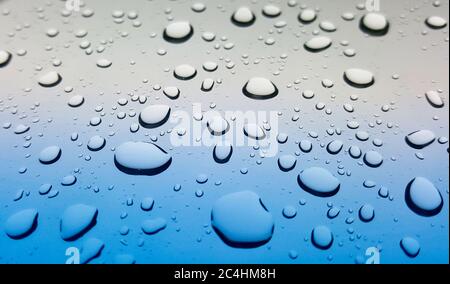 Éclaboussures de gouttes de pluie sur le pare-brise d'une voiture après une tempête. Point de vue incliné pour la profondeur de champ et la mise au point sélective. Banque D'Images