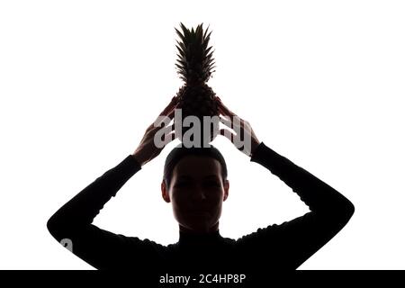 Ananas dans les mains d'une femme au-dessus de la tête - silhouette sur fond blanc Banque D'Images