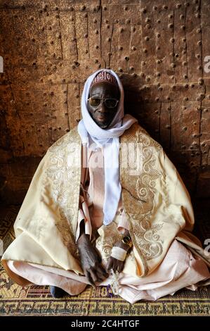 NIGER , Zinder, palais du sultan von DAMAGARAM El Hadji ABOUBACAR OUMAROU SANDA , portrait d'un inconnu à l'entrée, portant un boubou en tissu damassé Banque D'Images