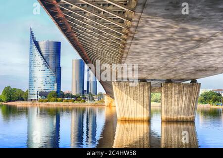 Vue sous le pont Vansu à Riga, Lettonie. Bâtiment moderne à gauche et piliers du pont à droite Banque D'Images