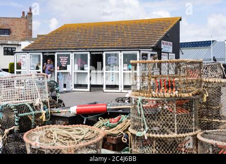 Pots de homard sur le quai de Mudeford avec magasin et stand vendant du poisson frais Banque D'Images