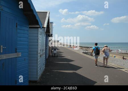 Norfolk, Royaume-Uni. 26 juin 2020. Un couple marche à côté des maisons de plage.les gens apprécient le soleil chaud sur la plage de Cromer car le temps en Angleterre a dépassé 30 degrés pour une troisième journée de course. Crédit : SOPA Images Limited/Alamy Live News Banque D'Images