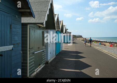 Norfolk, Royaume-Uni. 26 juin 2020. Un couple marche à côté des maisons de plage.les gens apprécient le soleil chaud sur la plage de Cromer car le temps en Angleterre a dépassé 30 degrés pour une troisième journée de course. Crédit : SOPA Images Limited/Alamy Live News Banque D'Images