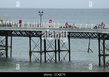 Norfolk, Royaume-Uni. 26 juin 2020. Les gens qui marchent sur la jetée de Cromer.les gens apprécient le soleil chaud sur la plage de Cromer car le temps en Angleterre a dépassé 30 degrés pour une troisième journée de course. Crédit : SOPA Images Limited/Alamy Live News Banque D'Images