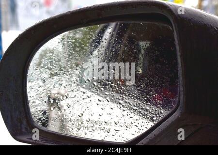 Gouttes de pluie à l'extérieur de la voiture par temps pluvieux. Vue de côté du miroir. Banque D'Images