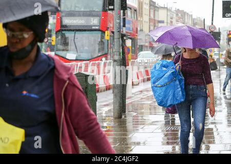 Londres, Royaume-Uni 27 juin 2020 - les femmes à l'abri de la pluie sous un parapluie dans le nord de Londres après une semaine très chaude qui a vu la température la plus élevée de l'année jusqu'à présent. Crédit: Dinendra Haria/Alay Live News Banque D'Images