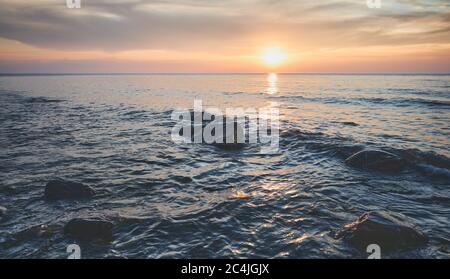 Paysage marin avec rochers dans l'eau au coucher du soleil, Miedzyzdroje, Pologne. Banque D'Images